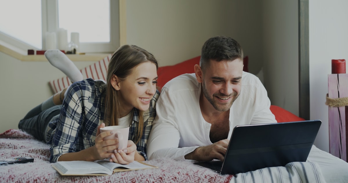 Una pareja planeando juntos con un café y un cuaderno
